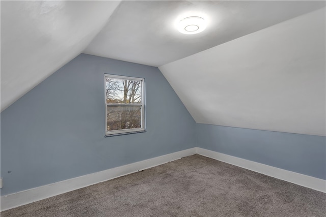 additional living space featuring lofted ceiling and carpet floors