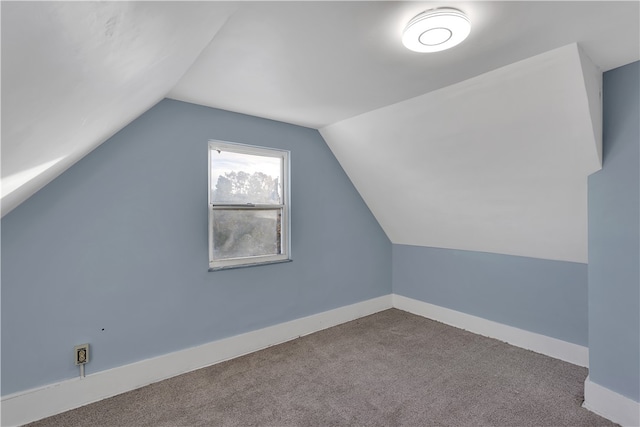 bonus room with light carpet and vaulted ceiling