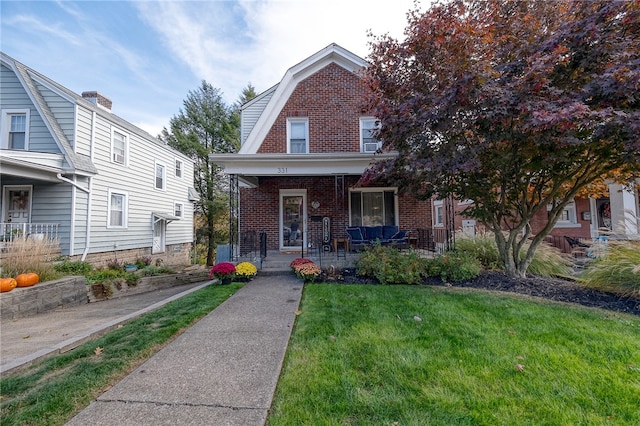 view of front of house with covered porch and a front lawn