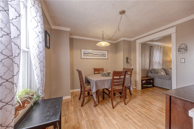 dining area featuring crown molding, a textured ceiling, and light wood-type flooring