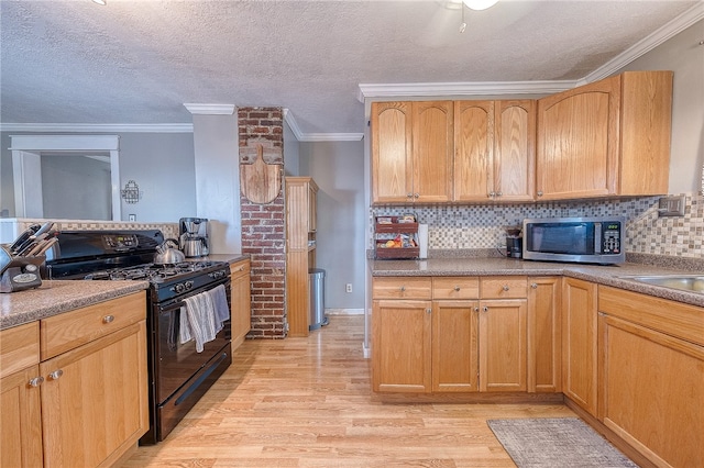 kitchen featuring ornamental molding, a textured ceiling, gas stove, and light wood-type flooring