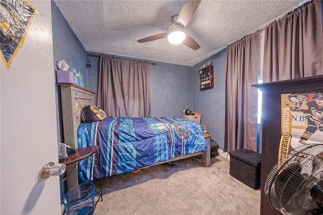 carpeted bedroom with a textured ceiling and ceiling fan