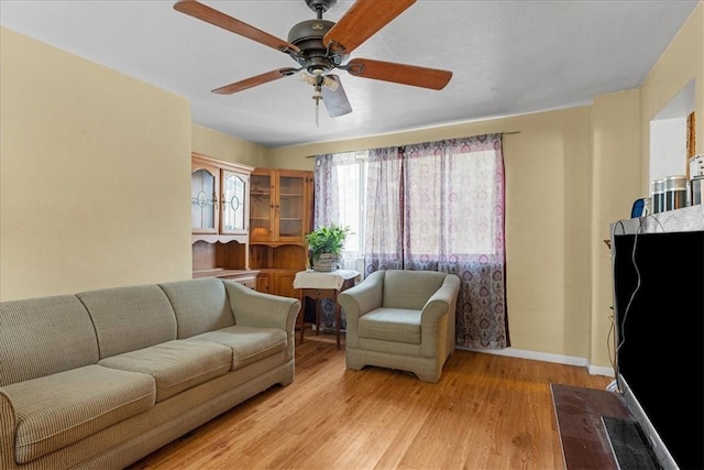 living room with light hardwood / wood-style flooring and ceiling fan