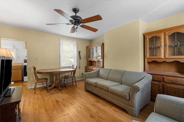 living room with light hardwood / wood-style flooring and ceiling fan