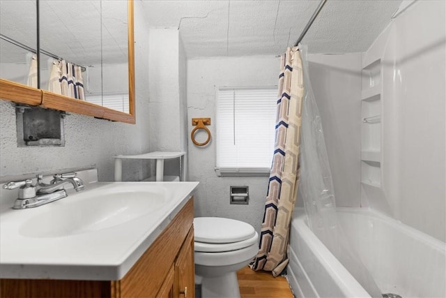 full bathroom featuring vanity, shower / tub combo with curtain, wood finished floors, toilet, and a textured ceiling