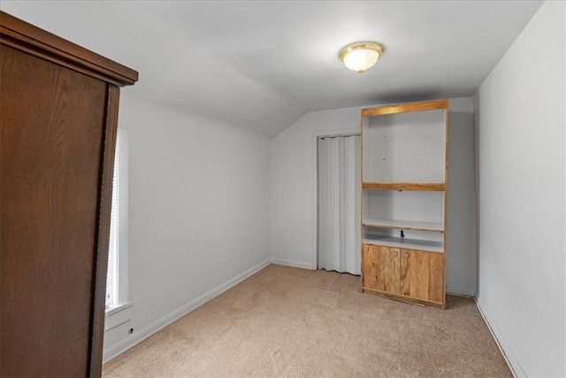 bonus room featuring light colored carpet and vaulted ceiling