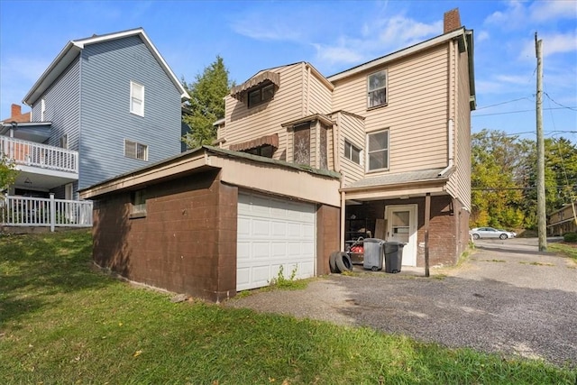 view of property exterior featuring a yard, gravel driveway, a chimney, and a garage