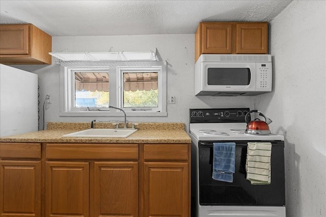 kitchen with a textured ceiling, sink, and white appliances