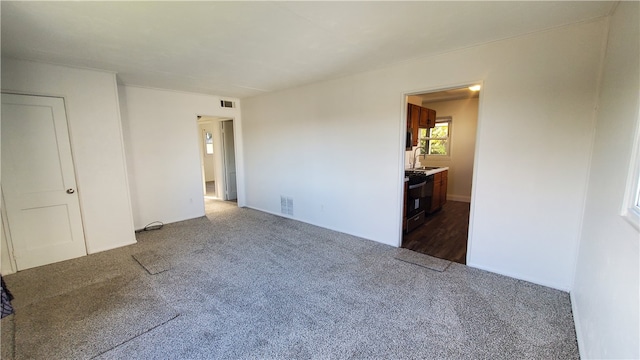 empty room with dark colored carpet and sink