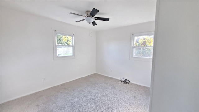 carpeted empty room with ceiling fan and a healthy amount of sunlight