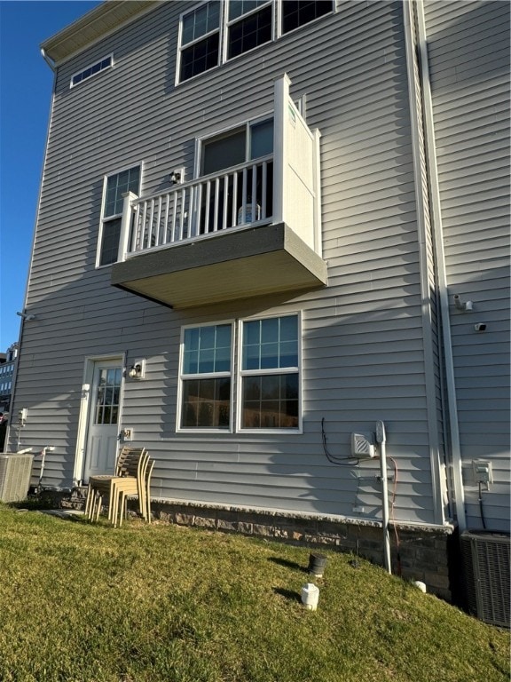 back of property featuring central AC, a yard, and a balcony