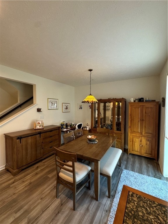 dining space with a textured ceiling and dark hardwood / wood-style floors