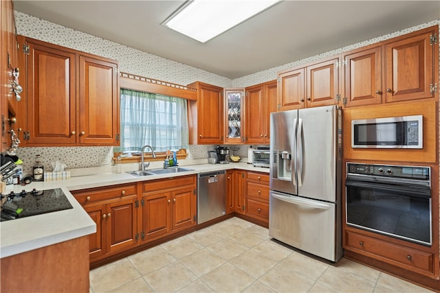 kitchen with sink, black appliances, light tile patterned floors, and tasteful backsplash