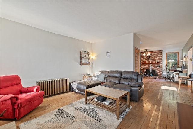 living room with radiator, ceiling fan, and hardwood / wood-style flooring