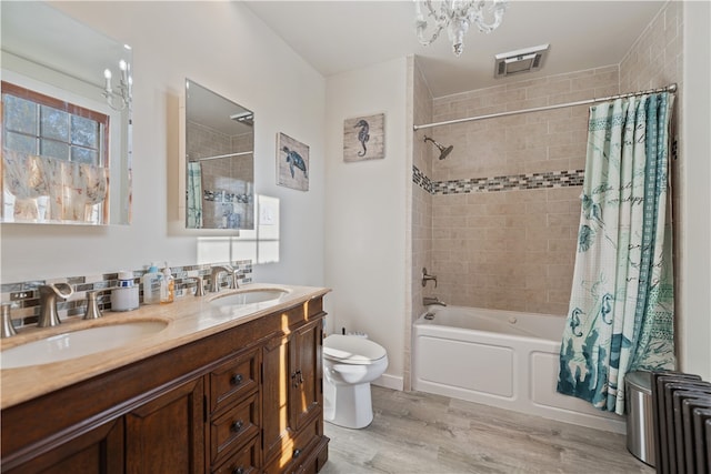 full bathroom featuring toilet, wood-type flooring, an inviting chandelier, vanity, and shower / bathtub combination with curtain