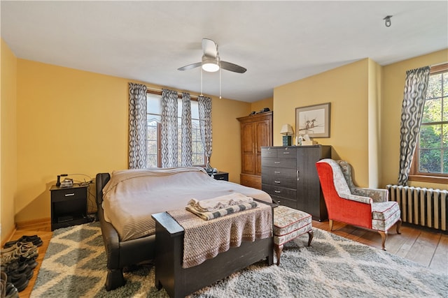 bedroom featuring ceiling fan, hardwood / wood-style flooring, and radiator heating unit