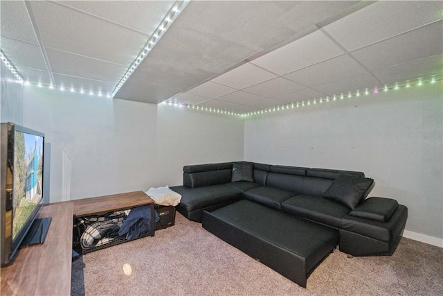 living room featuring a paneled ceiling and carpet