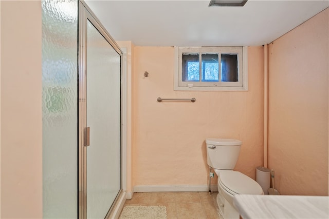 bathroom featuring a shower with shower door, toilet, and tile patterned flooring