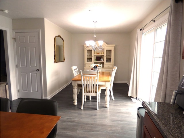 dining space with dark hardwood / wood-style floors and a notable chandelier