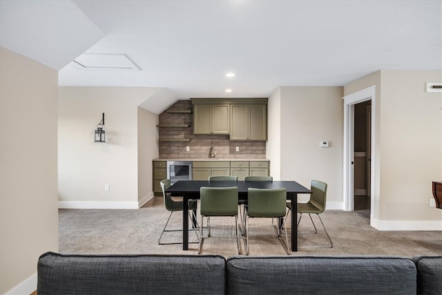 carpeted dining space with sink and beverage cooler