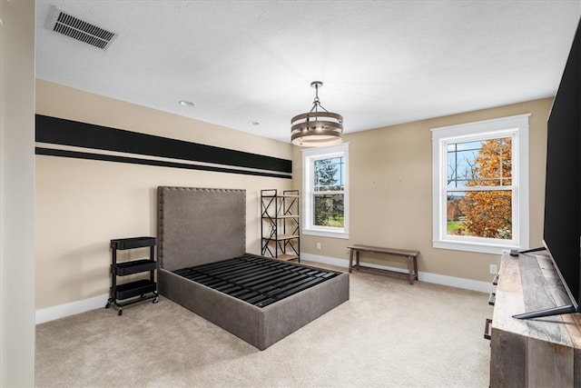 carpeted bedroom featuring a chandelier and a textured ceiling