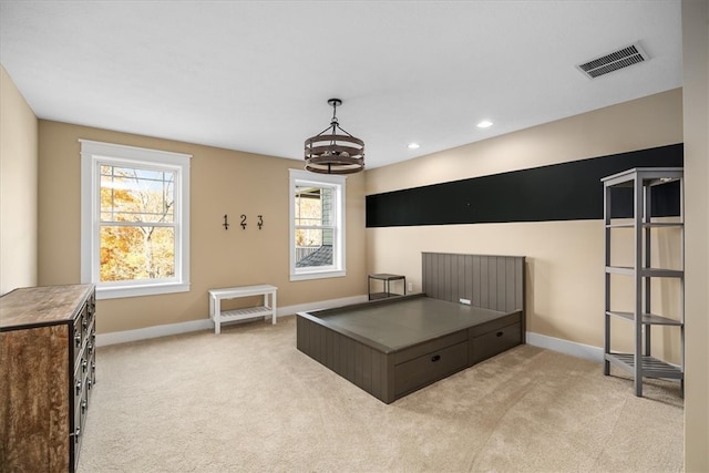 bedroom featuring a chandelier and light colored carpet