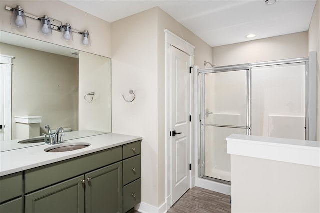 bathroom with vanity, a shower with shower door, and hardwood / wood-style floors