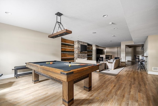 playroom featuring hardwood / wood-style floors, billiards, built in shelves, and a textured ceiling