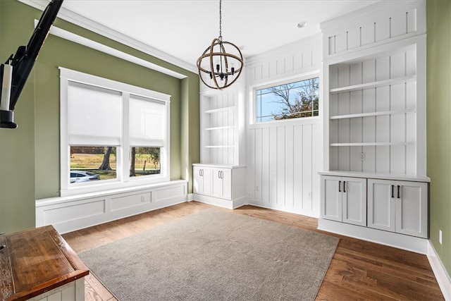 unfurnished dining area featuring a notable chandelier, dark hardwood / wood-style floors, built in features, and a wealth of natural light