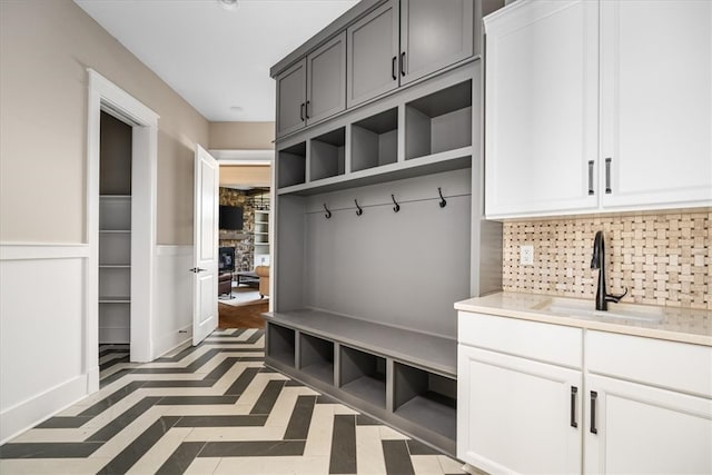 mudroom featuring a stone fireplace and sink