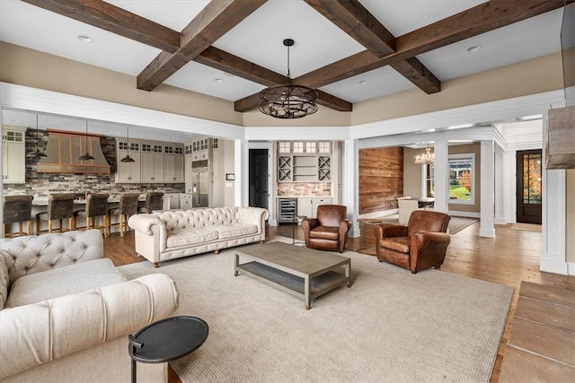 living room with a notable chandelier, beam ceiling, and coffered ceiling