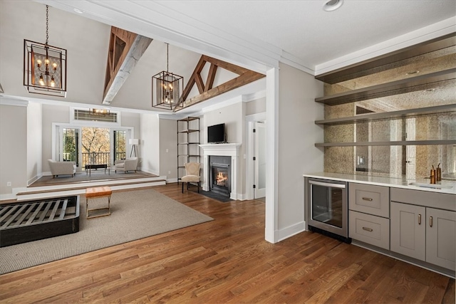 bar featuring wine cooler, hanging light fixtures, dark hardwood / wood-style flooring, and gray cabinets