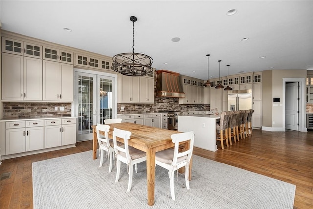 dining area with a chandelier, hardwood / wood-style flooring, and french doors