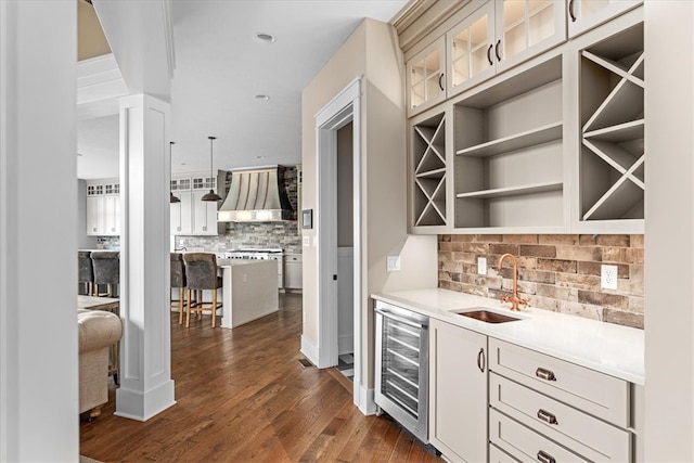 bar with wall chimney range hood, wine cooler, tasteful backsplash, dark hardwood / wood-style flooring, and sink