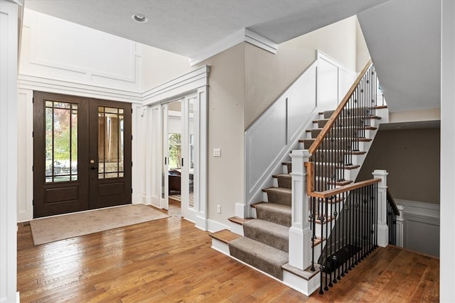 foyer entrance with french doors and hardwood / wood-style flooring