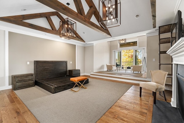 living room featuring beam ceiling, wood-type flooring, a tiled fireplace, and high vaulted ceiling