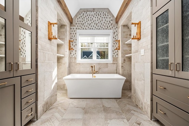 bathroom featuring tile walls, lofted ceiling, and a washtub