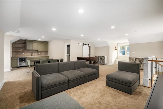 living room featuring light colored carpet, wine cooler, and a barn door