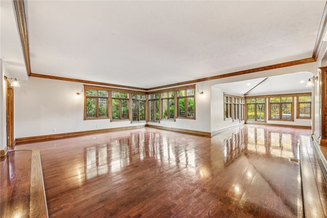 unfurnished living room featuring ornamental molding, wood-type flooring, and plenty of natural light