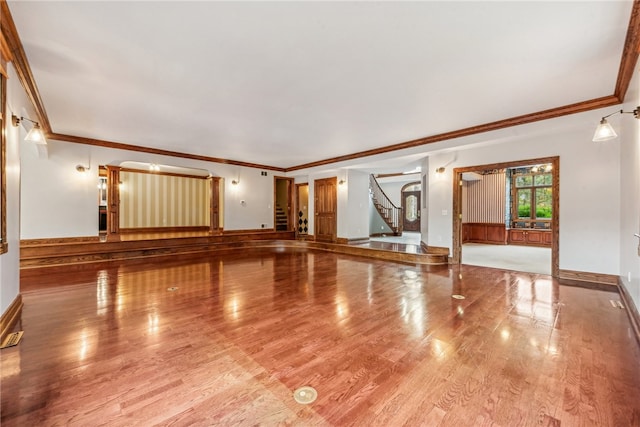 unfurnished living room with light hardwood / wood-style floors and crown molding