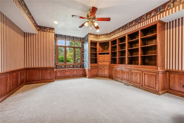 interior space featuring light carpet and ceiling fan