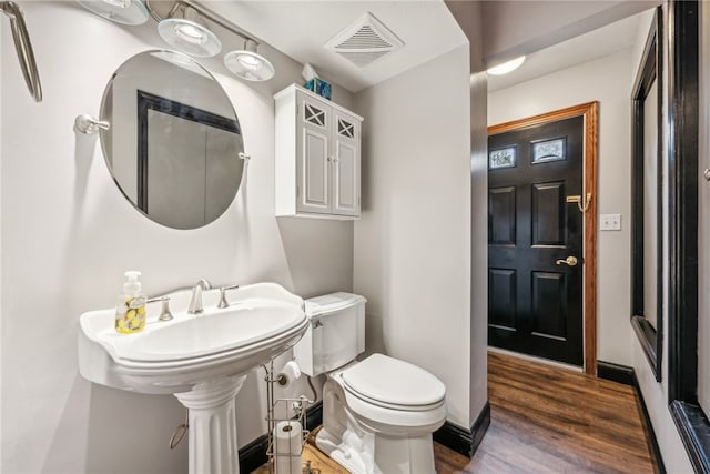 bathroom with hardwood / wood-style floors and toilet