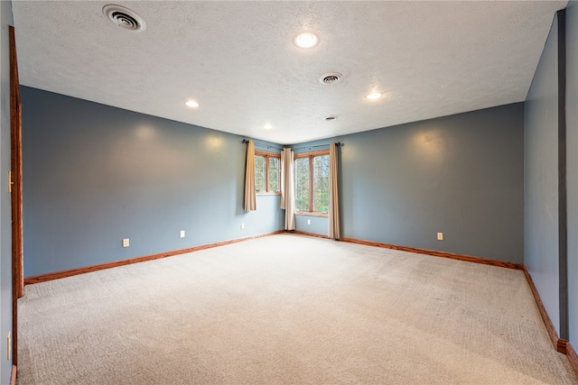 carpeted spare room with a textured ceiling