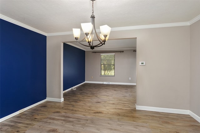 empty room featuring ornamental molding, hardwood / wood-style flooring, a chandelier, and a textured ceiling