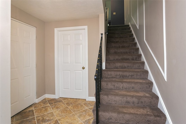 staircase with a textured ceiling