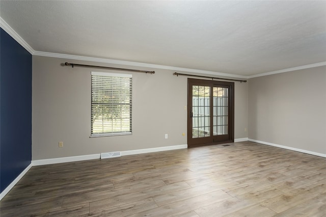 empty room with crown molding, a textured ceiling, and light hardwood / wood-style flooring