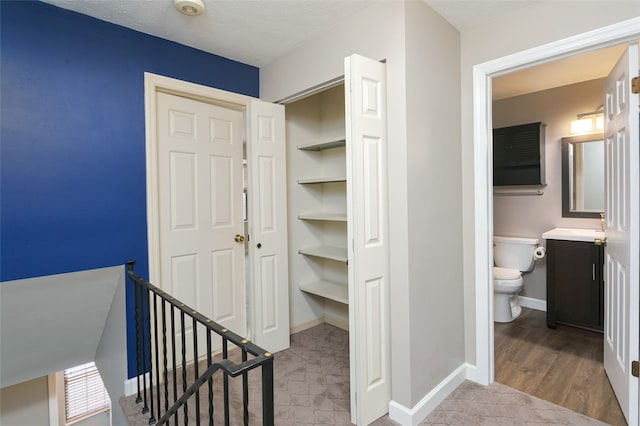 interior space featuring built in features, a textured ceiling, and light wood-type flooring