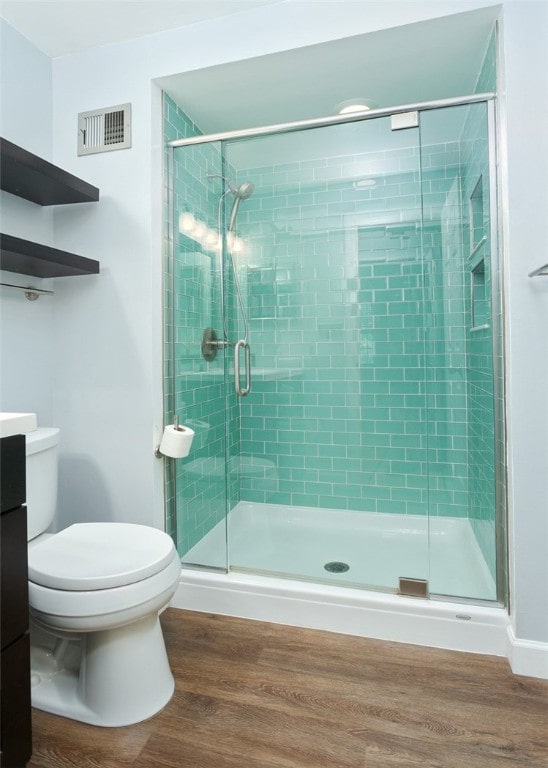 bathroom with vanity, toilet, wood-type flooring, and an enclosed shower