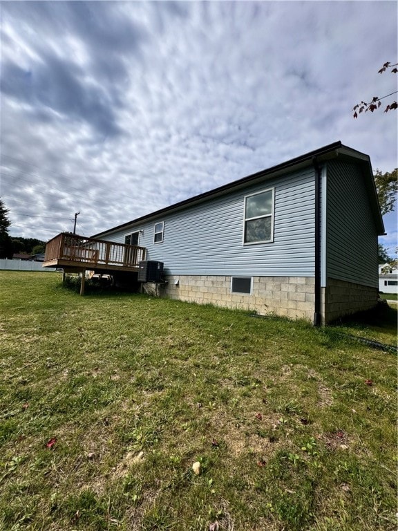 view of side of home featuring a wooden deck and a yard