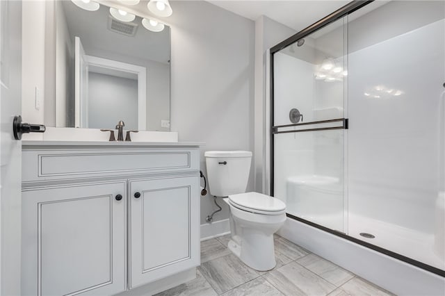 bathroom featuring vanity, toilet, and walk in shower